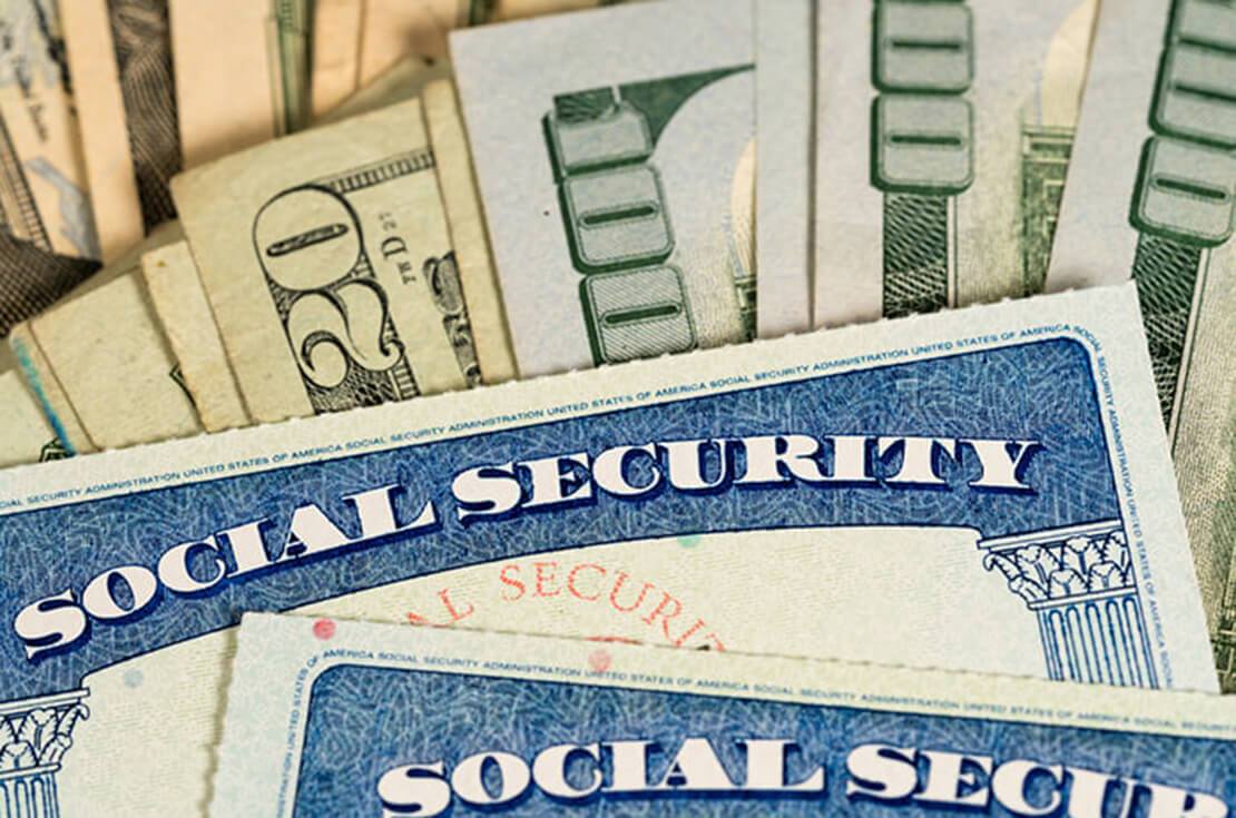 Social security cards in front of US dollar bills