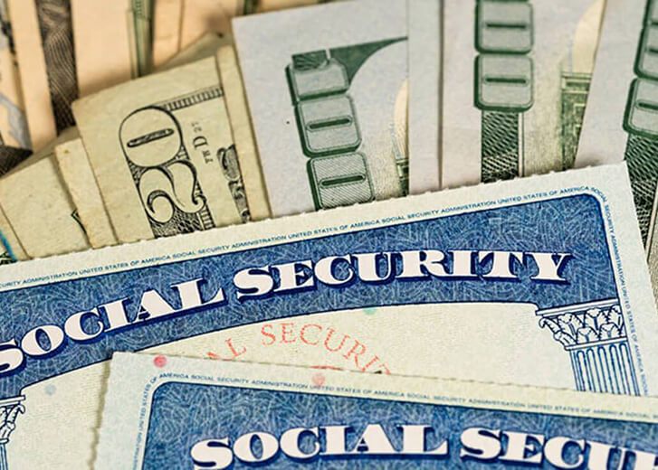 Social security cards in front of US dollar bills